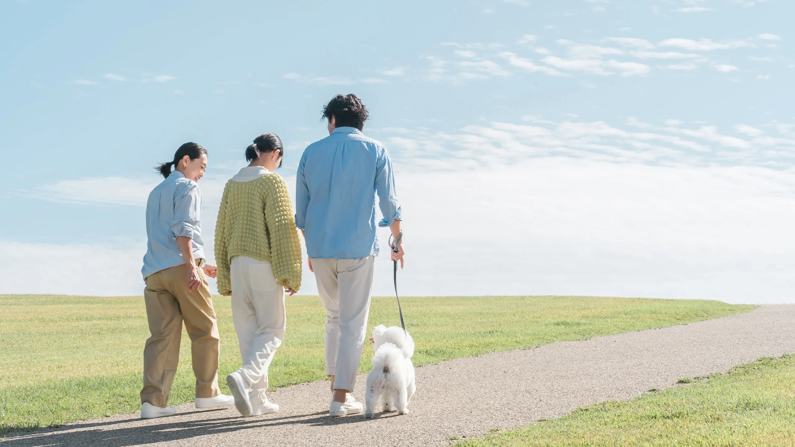 家族と犬が一緒に散歩する画像